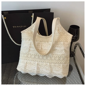 Detail der weißen Spitze-Beuteltasche mit dreistufigen Rüschen und floraler Netzstruktur