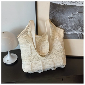 Detailansicht der beigen Spitzen-Tote Bag mit Blumenmustern und Rüschen im Kunstatelier