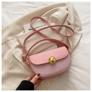 Detail of pink saddle bag featuring tweed patchwork and a golden geometric buckle