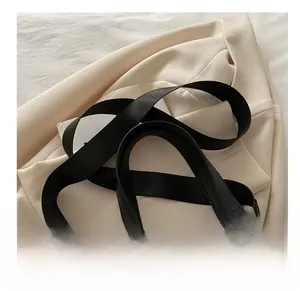 Detail eines verstellbaren schwarzen Web-Schultergurts mit Goldschnalle für Taschen