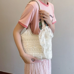 Elegante weiße Strandtasche aus Spitze mit großer Schleife für den Sommerurlaub