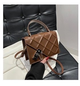 Detail of brown quilted leather bag featuring gold hardware and elegant chain strap