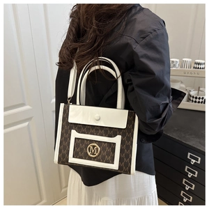 Detail shot of a fashion tote bag with M-letter monogram print and white leather trim