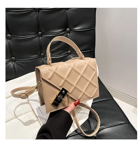 Detail of beige quilted handbag featuring a golden square lock and elegant chain accent