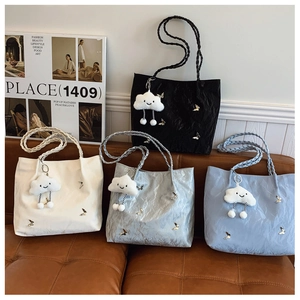 Dettaglio borse shopper a pieghe in quattro colori con farfalle e ciondoli di peluche