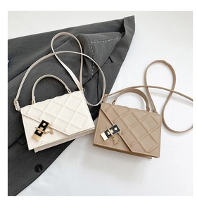Detail of quilted leather pattern and metal clasp on beige and khaki shoulder bags