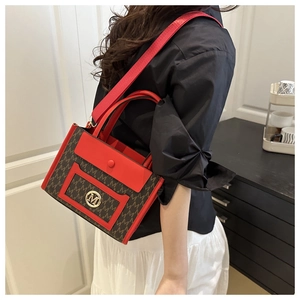 Close-up of Large tote bag with M print canvas, red leather trim and gold metal logo