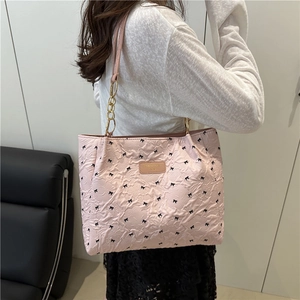Sac fourre-tout matelassé rose avec broderie de nœuds noirs et chaîne dorée