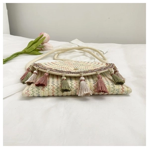Détail du sac selle bohème avec texture tissée, broderie arc-en-ciel et pompons colorés