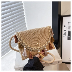 Détail du sac à selle en paille avec broderies pailletées dorées et glands colorés