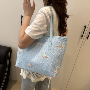 Light blue embroidered butterfly tote bag with quilted pattern and shoulder straps