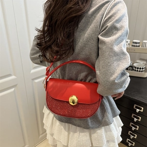 Chic red sequin saddle bag for women with gold round buckle shown on a model's shoulder