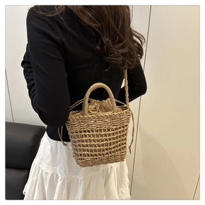 Detailed back view of a model wearing the woven flower bucket bag with drawstring closure