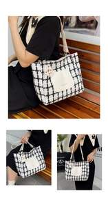 Detail of tweed checkered tote bag with white leather pocket and cat charm on a park bench