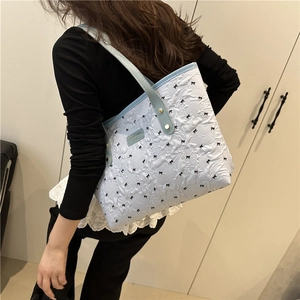 Light blue tote bag with white floral texture and black 3D bows for shoulder wear
