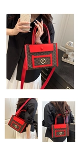 Macro detail of red leather handles and gold metal M logo on printed monogram tote bag