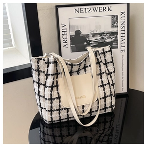 Detail of checkered tweed tote bag featuring a magnetic front pocket and golden text
