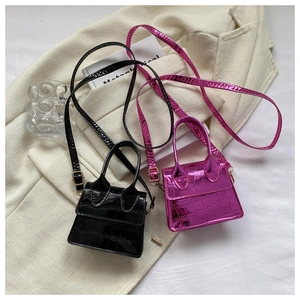 Detailed view of crocodile texture mini handbags in black and metallic rose pink finish