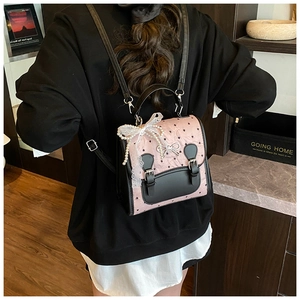Detailansicht eines rosa Rucksacks mit Herzmuster, Spitze und Schleifendetails