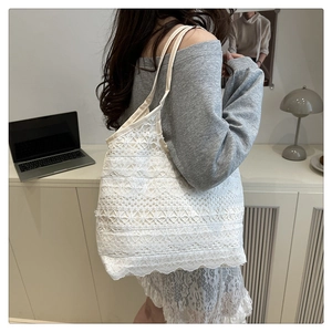 Detailed view of white lace embroidered tote bag with layered floral ruffles and straps