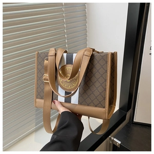 Detailansicht der großen Monogramm-Tasche mit schwarz-weißen Streifen und Gold-Logo