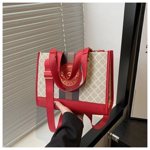Detail der weißen Segeltuchtasche mit rotem Lederbesatz und Nylon-Schultergurt