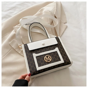 Detail of brown and white tote bag with M monogram print and gold metallic logo