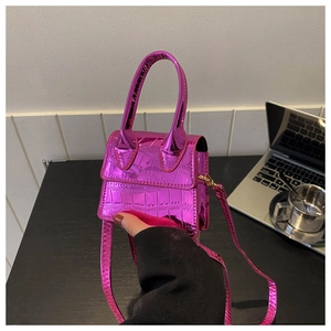 Close-up of metallic purple mini handbag with embossed crocodile pattern and handle
