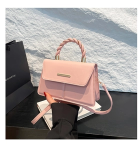 Détails du sac bandoulière rose clair avec poignée tressée et finitions dorées chic