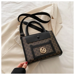 Close-up of the vintage monogram pattern and gold M logo on the leather tote bag