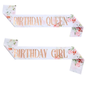 Detail of white satin Birthday Queen and Birthday Girl sashes with floral print