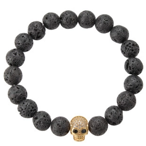 Detailed shot of black lava rock bead bracelet with gold micro-pave skull charm accessory