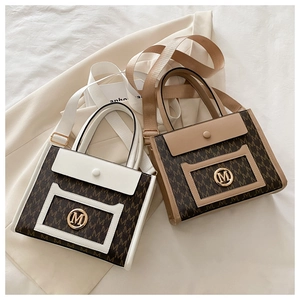 Detailed view of canvas tote bags with M monogram pattern and golden metal logo charm