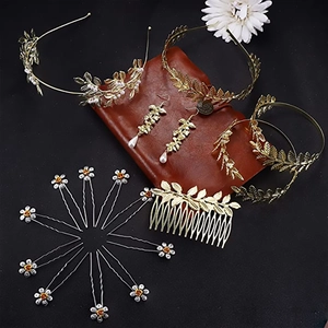 Détails d'une parure de mariée bohème avec feuilles dorées, perles et marguerites