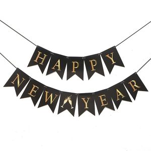 Detalle de pancarta Happy New Year con letras doradas y diseño de copas de champán