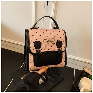 Detail des rosa gerafften Rucksacks mit schwarzen Herzprints und Metallbogendekor