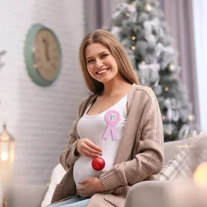 Close-up of a pink Mommy to Be badge with satin ribbons worn by an expectant mother