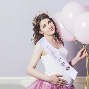 Close-up of Mom to Be satin sash and sparkling rhinestone tiara set for baby shower