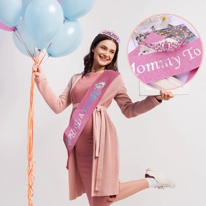 Rosafarbene Mommy To Be Schärpe mit Kristallkrone, getragen bei einer Babyparty