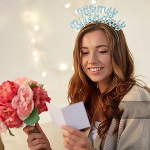 Close-up of silver birthday headband with blue glitter 'It's my Birthday' text on model