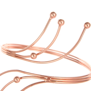 Rose gold multilayer open sun bracelet with spherical bead ends on a white background