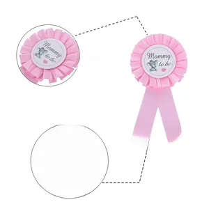 Close-up of pink Mommy to be baby shower badge featuring a crowned elephant and satin ribbon