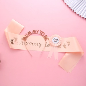 Macro detail of baby shower set with rose gold mummy to be tiara and daddy to be badge
