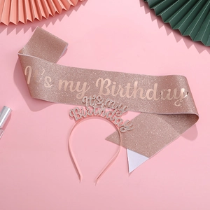 Detail of rose gold birthday sash and rhinestone headband set on pink background