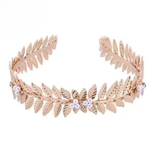 Detailed view of golden leaf headband with white pearls and sparkling rhinestones