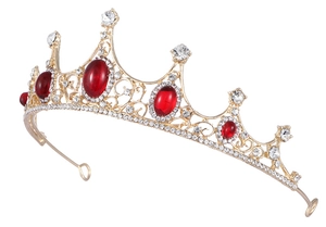 Vue latérale de la couronne baroque dorée avec cristaux rouges et strass brillants