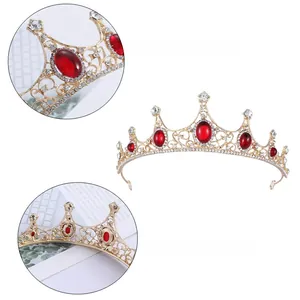 Détails d'une couronne en cristal doré avec de gros rubis rouges et métal ciselé