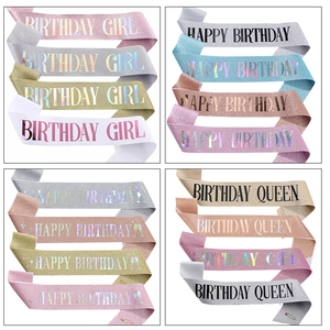 Detail of glitter fabric birthday sashes in various colors with metallic lettering
