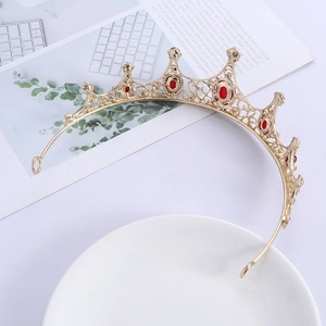 Detailed macro of gold vintage baroque crown with red crystals and hollow pattern
