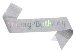 Close-up of silver glitter birthday sash featuring laser rainbow It's my Birthday text
